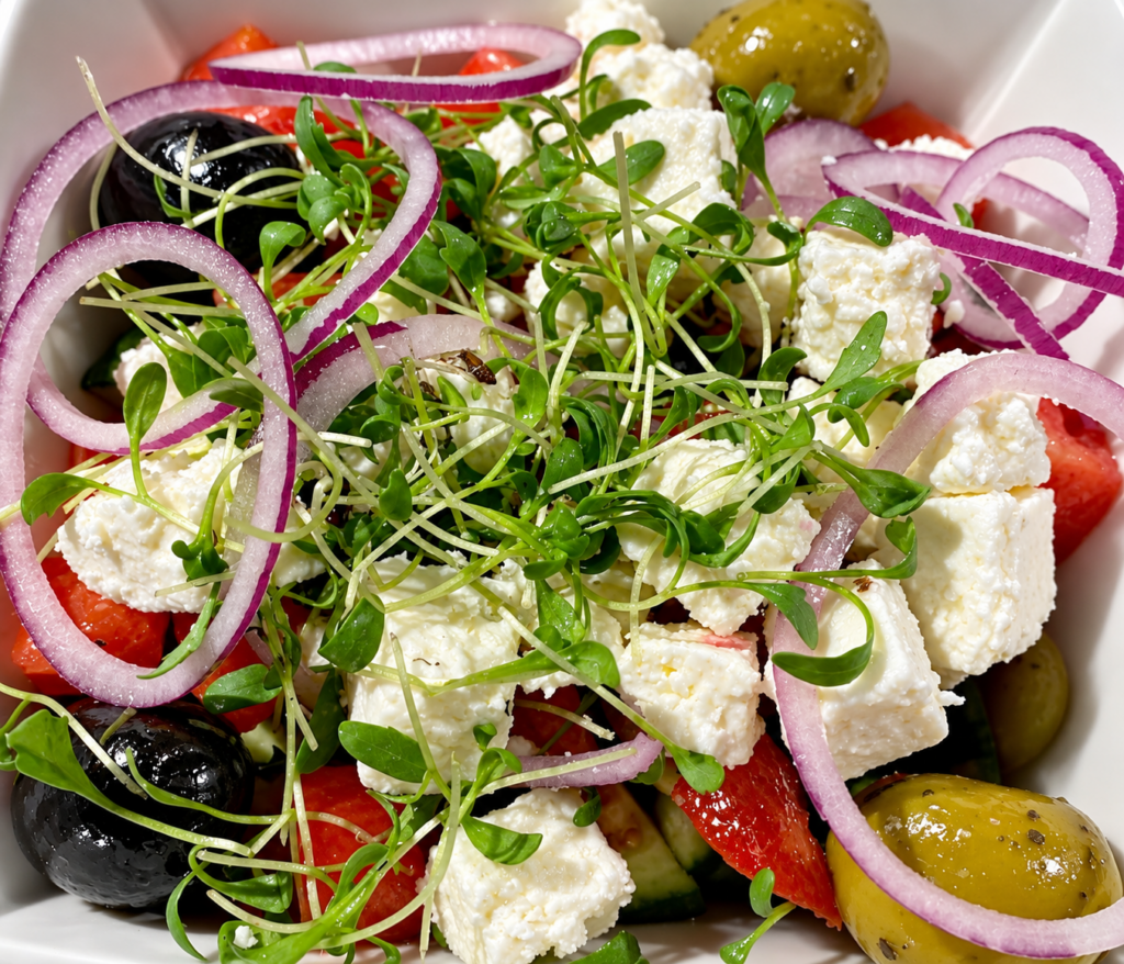 Salat mit Feta, Tomaten, roten Zwiebeln, Oliven und frischer Kresse